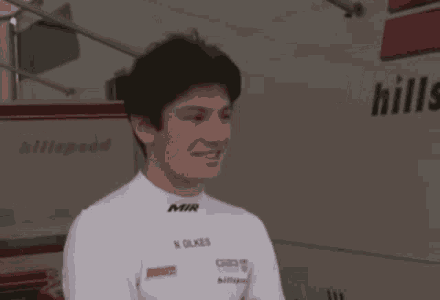 a man wearing a white shirt with mir on it