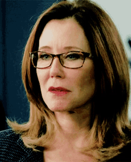 a close up of a woman wearing glasses making a sad face