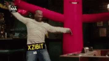 a man wearing a sweater that says xzibit is dancing