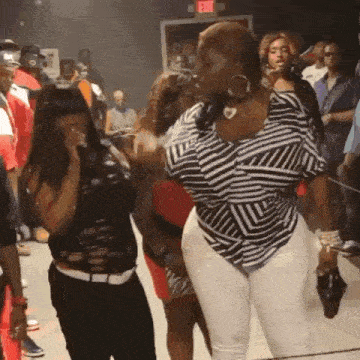 a woman in a striped shirt is dancing in a crowd .