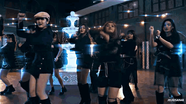 a group of girls are dancing in front of a fountain with the words jejeisan48 on the bottom right