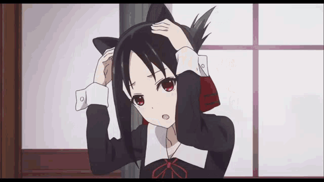 a girl with cat ears on her head holds her head