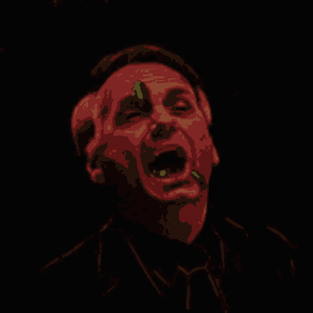 a man in a suit and tie is screaming in a dark room with his mouth open .