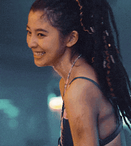 a woman with dreadlocks is smiling and wearing a bra