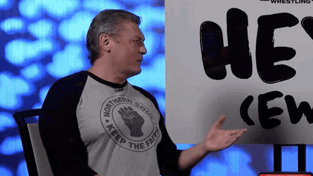 a man wearing a shirt that says " keep the faith " on it