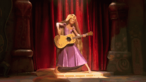a woman in a purple dress is playing a guitar on stage