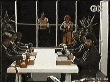 a group of people are sitting around a table with a gifrun.com logo on the bottom
