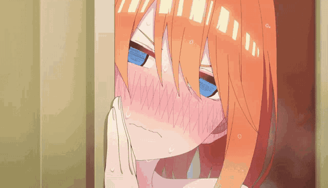 a close up of a girl with orange hair and blue eyes covering her mouth with her hand .