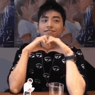 a man making a heart shape with his hands