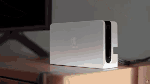 a white nintendo switch console is sitting on a wooden table