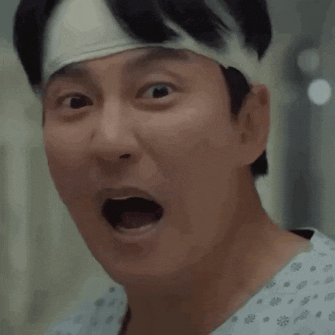 a man with a bandage on his head is making a face .