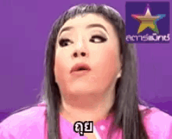 a woman in a pink shirt is making a face in front of a star logo