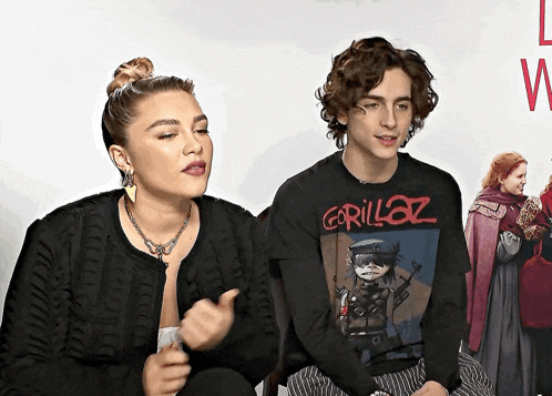 a man and a woman are sitting next to each other and the man is wearing a gorillaz t-shirt