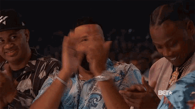 a group of men are applauding in a stadium with bet written on the bottom