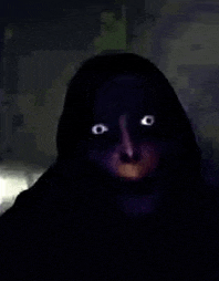 a close up of a person 's face in the dark with bright eyes .