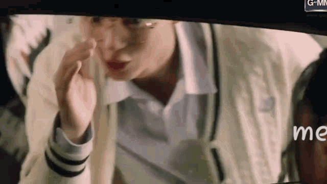 a close up of a person covering their face with their hand while sitting in a car .