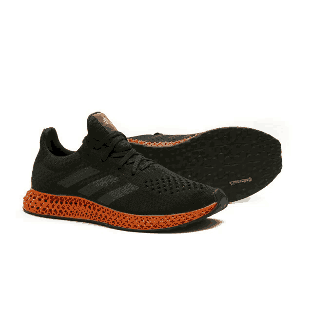 a pair of black and orange adidas shoes with continental rubber