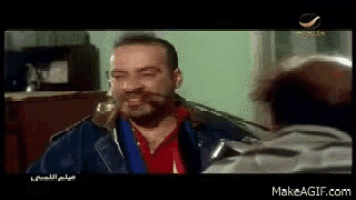 a man with a beard is talking to another man in a movie .