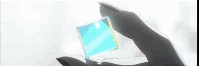 a person is holding a blue cube in their hand with a white background .