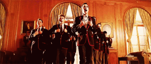 a group of men in suits are standing in a room .