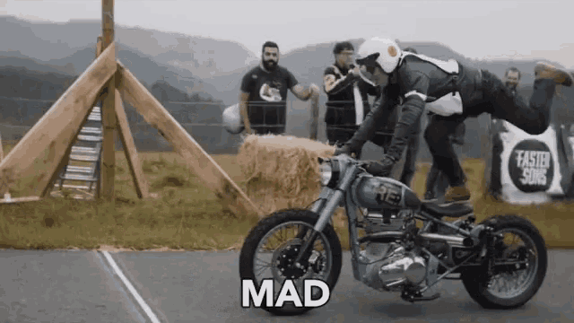 a man is riding a motorcycle with the word mad written on the front