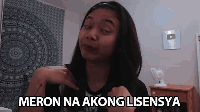 a girl is making a funny face with the words meron na akong lisensya written below her