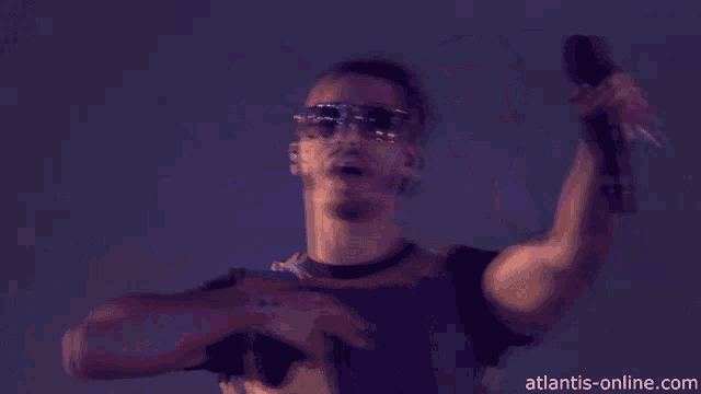 a man wearing sunglasses and a number 8 shirt holds a microphone