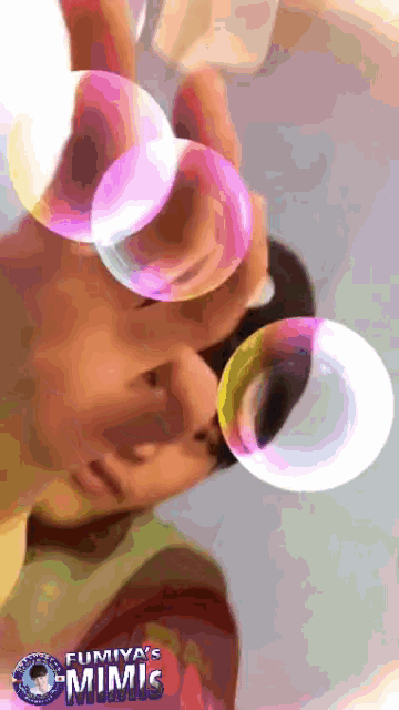 a person blowing soap bubbles with the name fumiya 's mimis on the bottom right
