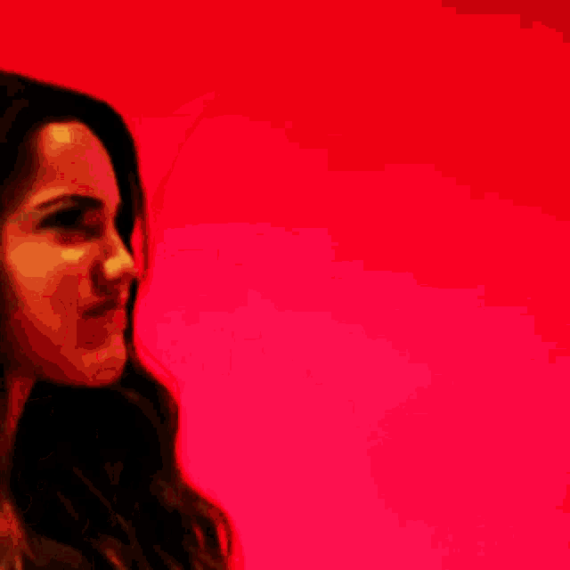 a woman with long hair is making an angry face in front of a red background