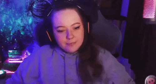 a girl wearing headphones is sitting in a gaming chair .