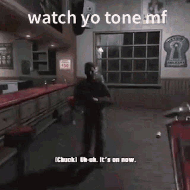 a man is standing in a room with a motorcycle and a sign that says watch yo tone mf .