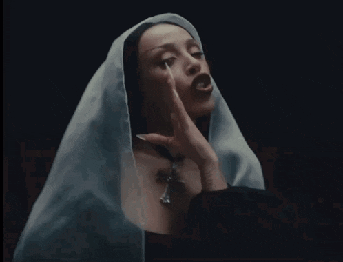 a woman with long white nails and a white veil on her head