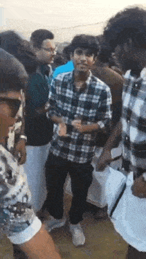 a group of young men are standing in a crowd of people .