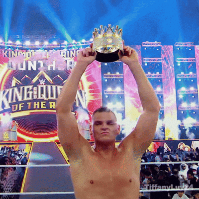 a shirtless wrestler holds up a trophy in front of a king of the ring sign