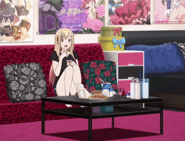 a girl is sitting on a couch in a room with posters on the wall