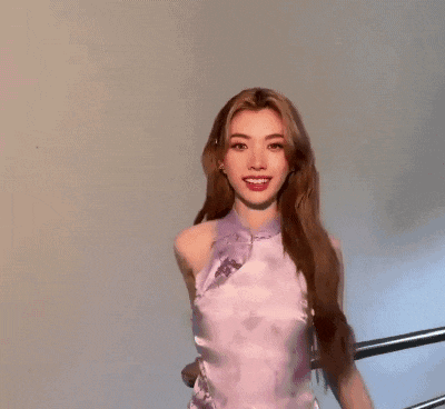 a close up of a woman wearing a purple top and smiling .