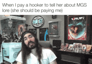 a man with long hair is sitting in front of a sign that says mgs on it