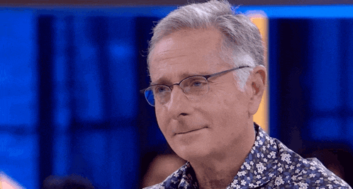 a man wearing glasses and a shirt with flowers on it