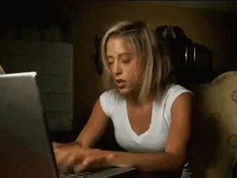 a woman is typing on a laptop computer in a dark room
