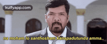 a man with a beard is wearing a suit and tie and says na moham lo santhosham kanapadutunda amma .