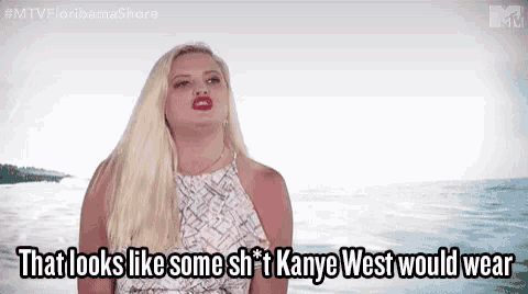 a woman is standing in front of the ocean and saying that looks like some shit kanye west would wear .