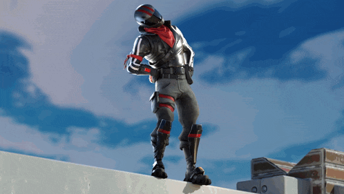 a video game character with a red scarf around his neck is standing on a wall