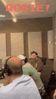 a group of people wearing headphones in a room with rosie written in red letters