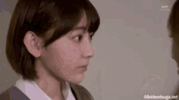 a woman in a suit and white shirt is looking at another woman .