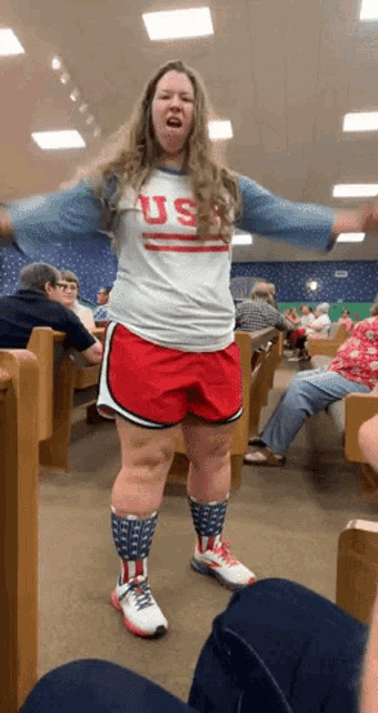 a woman wearing red shorts and a shirt that says us on it
