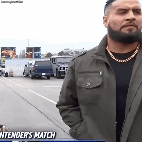 a man with a beard is standing in a parking lot with the words " stender 's match " on the screen