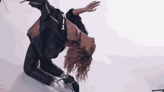 a woman in a plaid shirt is doing a handstand on a white background