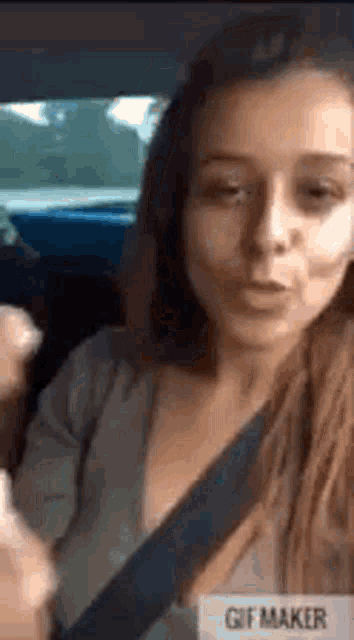 a woman is sitting in a car with a seat belt on .