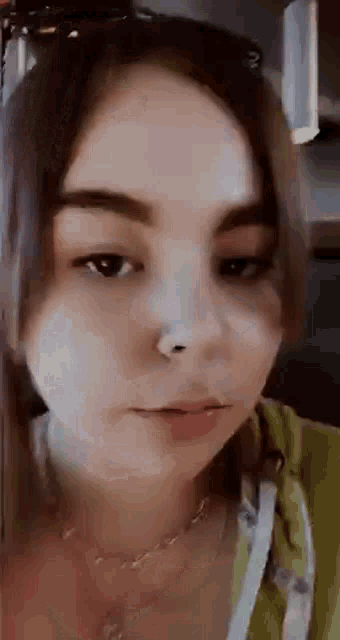 a close up of a woman 's face with a nose ring on her nose .