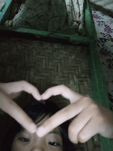a person making a heart shape with their fingers